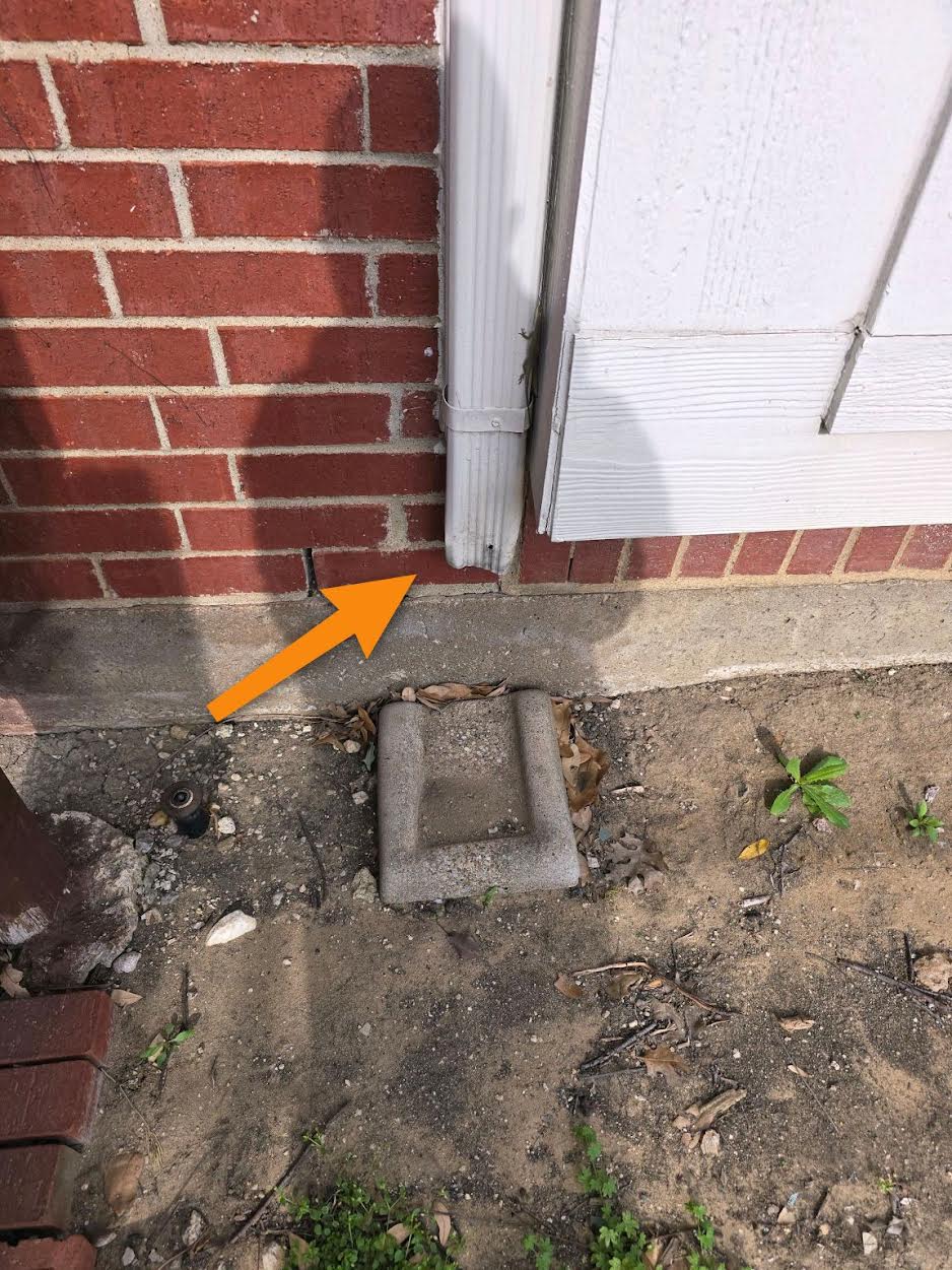 Downspout discharging directly against the foundation instead of away from the home in McKinney, TX