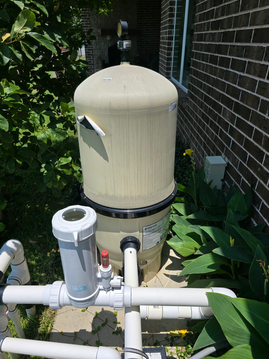 Pool cartridge filter, pressure gauge, and inline chlorinator on the equipment pad, documented on a North Texas pool inspection